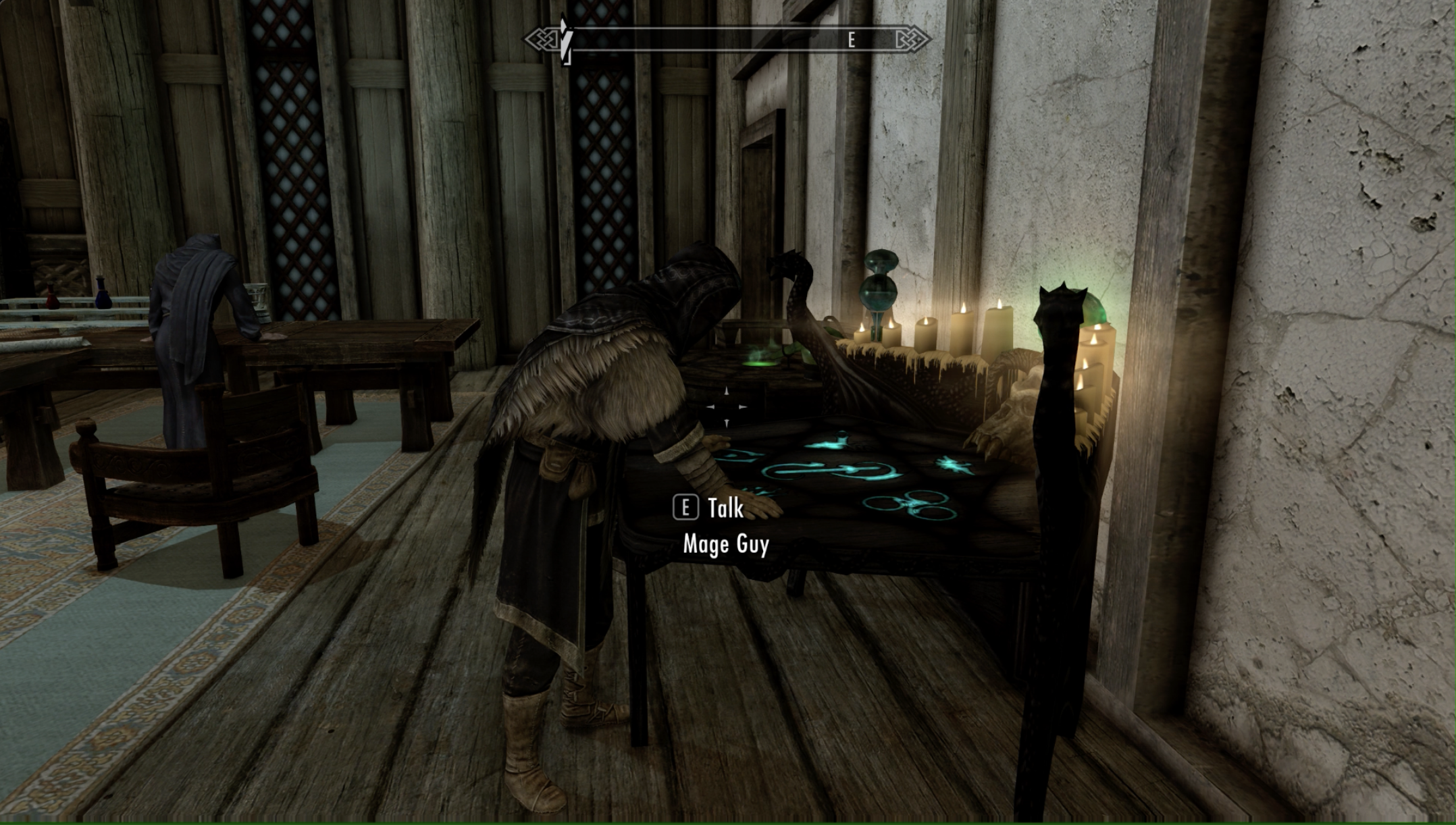 Mage Guy Follower leans against an enchanting table in Skyrim.
